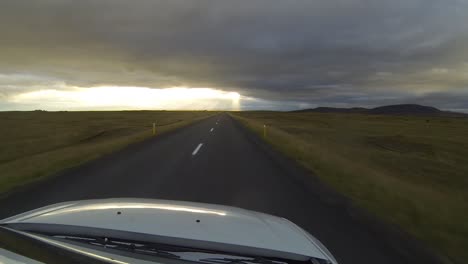 Straßenzeitraffer-In-Island-Bei-Sonnenuntergang.-Blick-Von-Oben-Auf-Ein-Fahrendes-Auto.